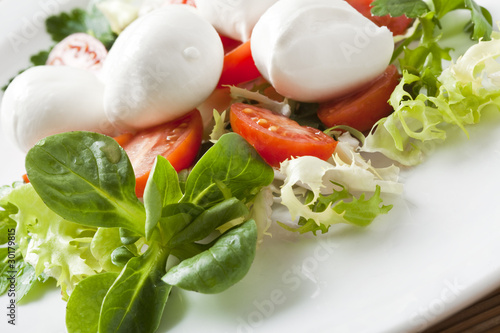 mozzarella and tomato on green salad, italian food