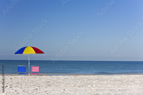 Colorful Beach Umbrella with Pink and Blue Deckchairs