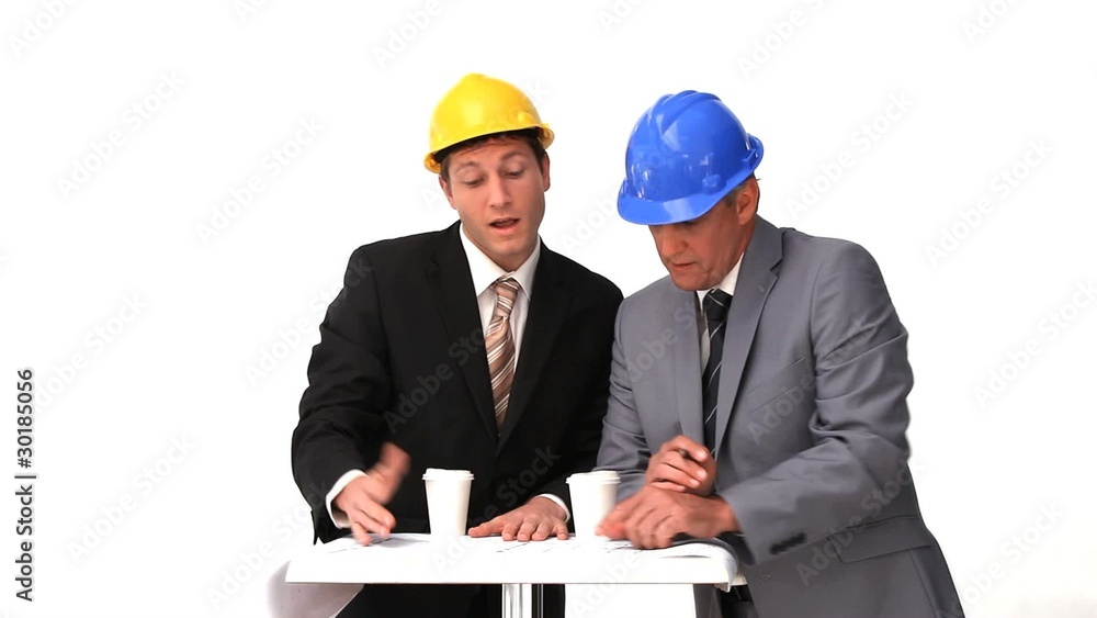 Two architects with safety helmets speaking Two architects with safety helmets speaking