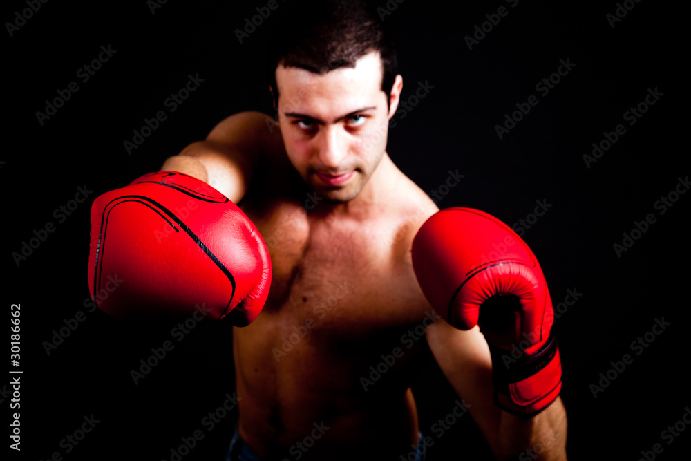 Young man punching in the dark