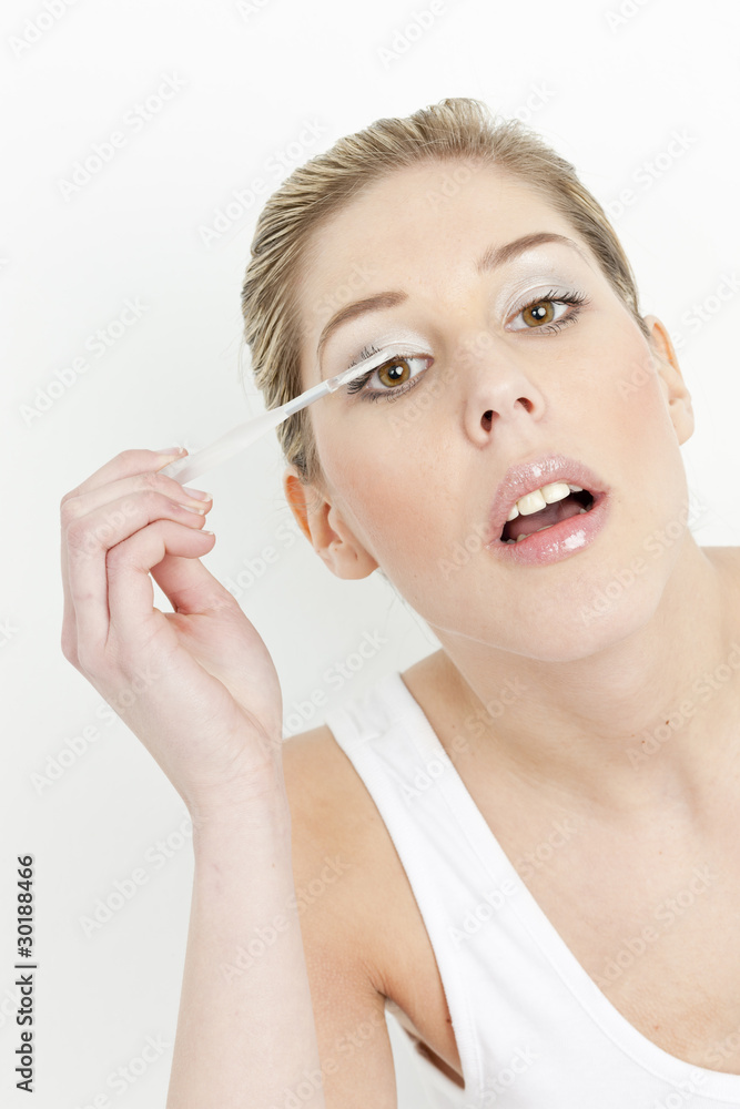 portrait of young woman putting on eye shadows