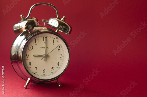 Alarm clock on red background photo