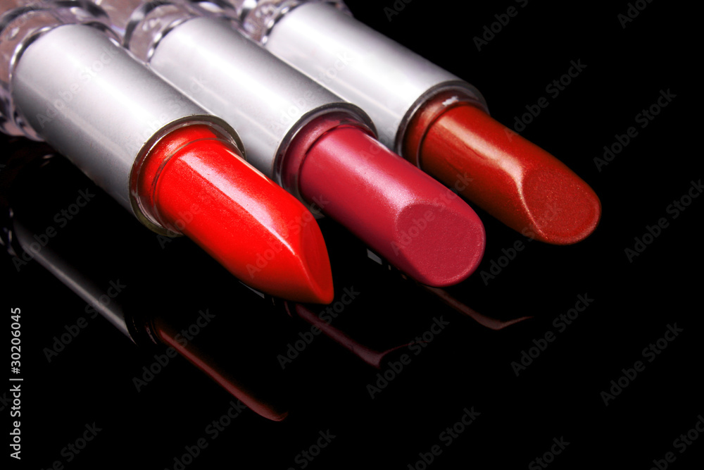 three bright lipsticks on a black background three bright lipsticks on a black background