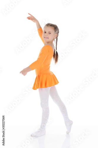 beautiful ballerina dancing in an orange dress.