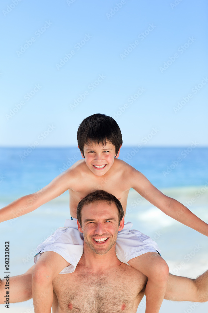 Father having son a piggyback on the beach Father having son a piggyback on the beach