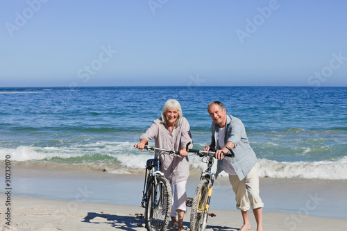 Senior couple with their bikes on the beach