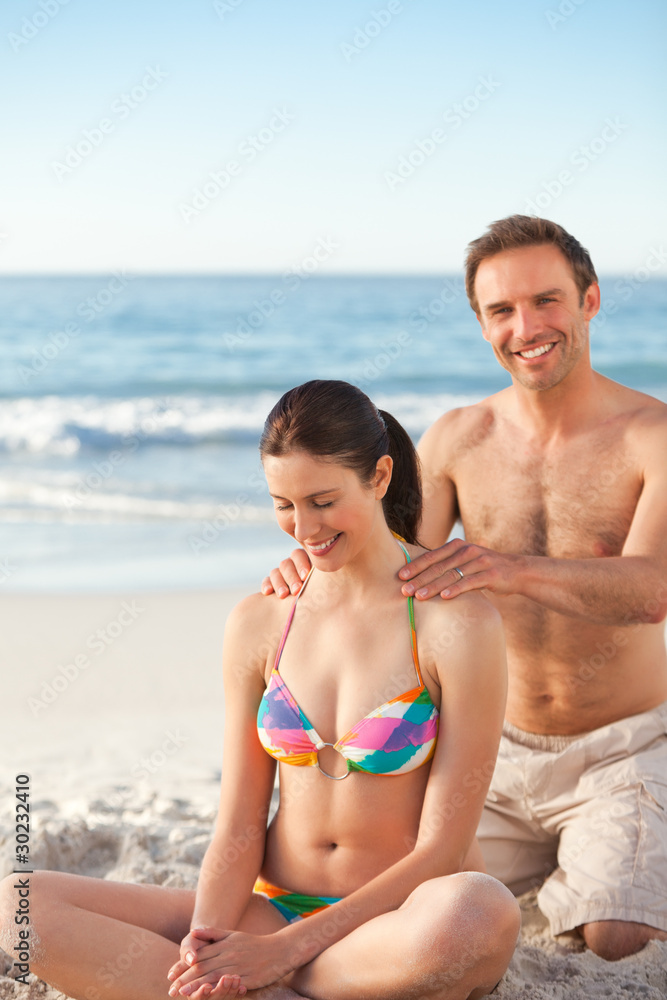 Man applying sun cream on his girlfriend's back Man applying sun cream on his girlfriend's back