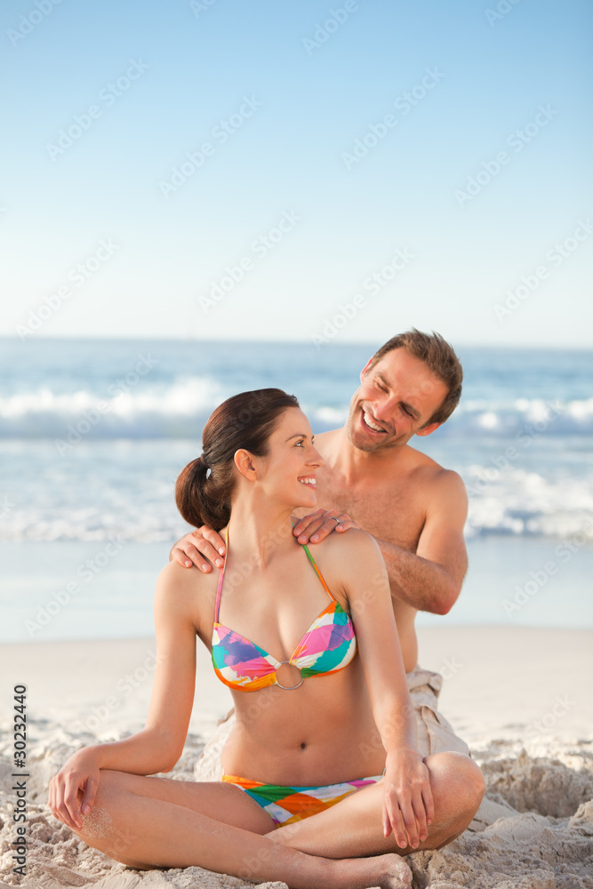 Attentive man applying sun cream on his girlfriend's back Attentive man applying sun cream on his girlfriend's back