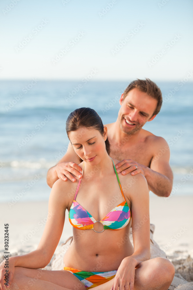Attentive man applying sun cream on his girlfriend's back Attentive man applying sun cream on his girlfriend's back