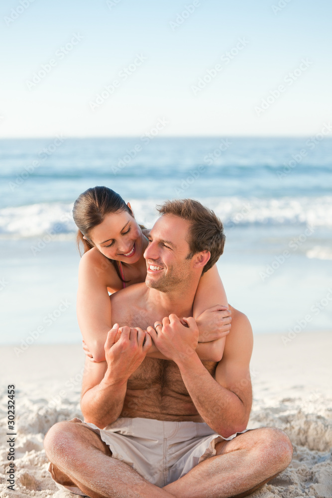 Enamored couple hugging on the beach