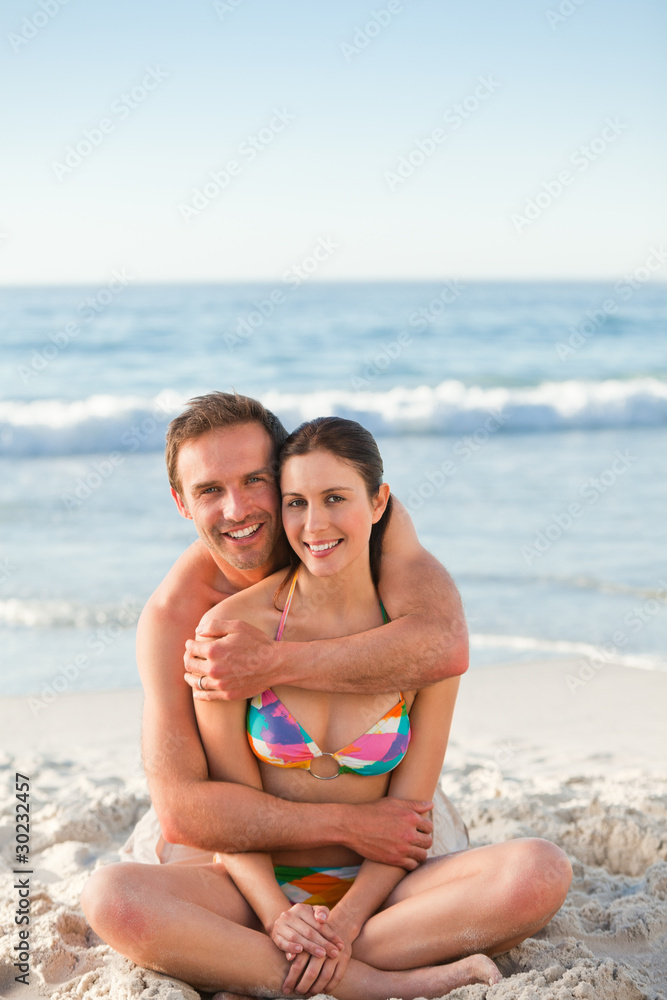 Enamored couple hugging on the beach