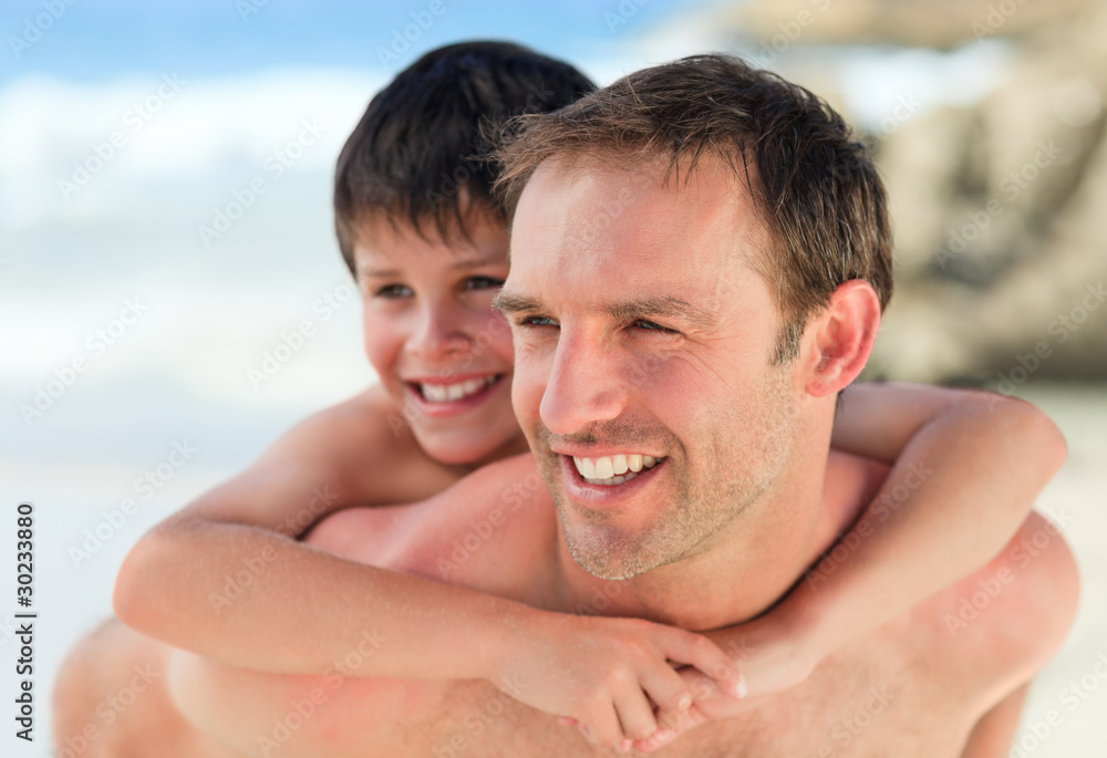 Father having son a piggyback on the beach Father having son a piggyback on the beach