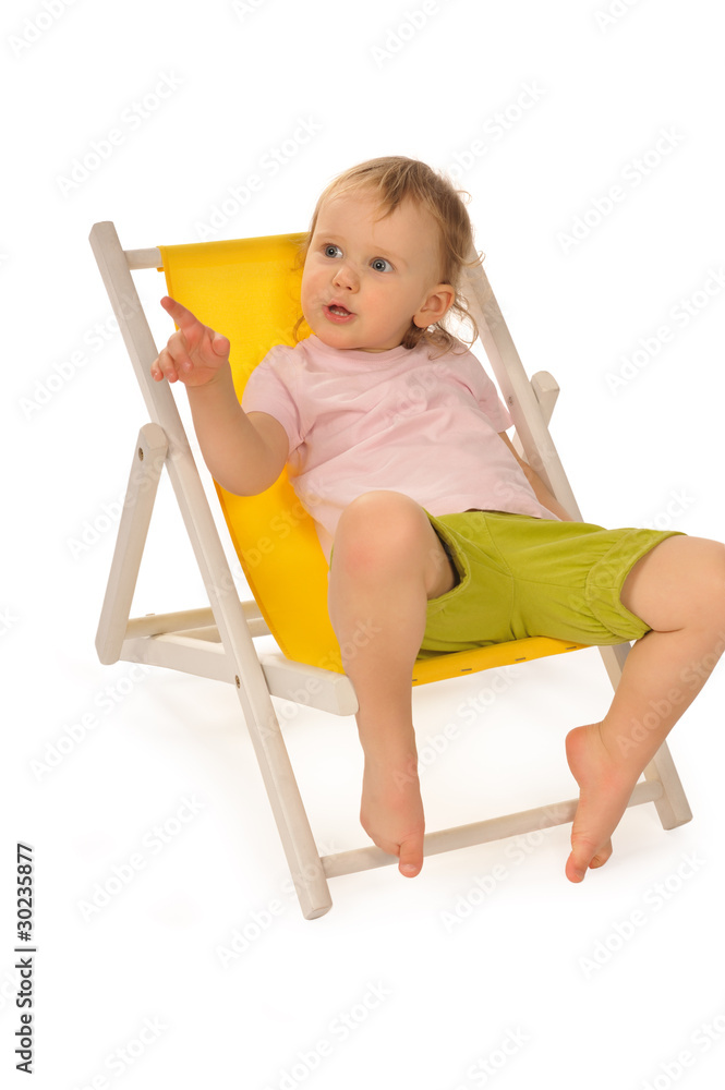 Funny little girl in studio on yellow deckchair Funny little girl in studio on yellow deckchair