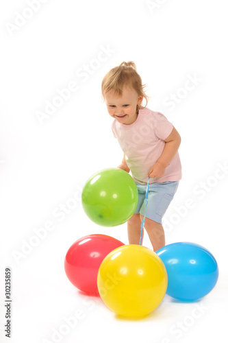 Baby in studiu is playing with balloons