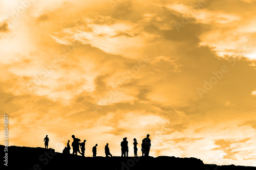 silhouette of people on peak of the cliff edge