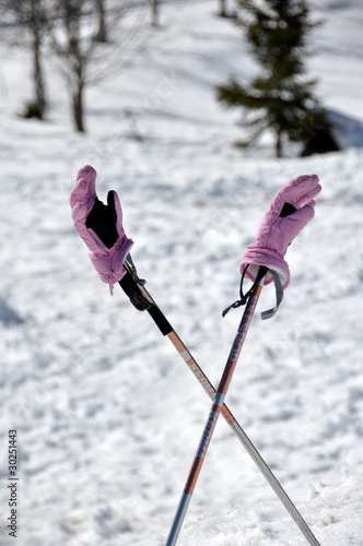 gants de ski roses et bâtons croisés neige