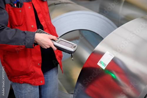 A worker has scanned steel roll production