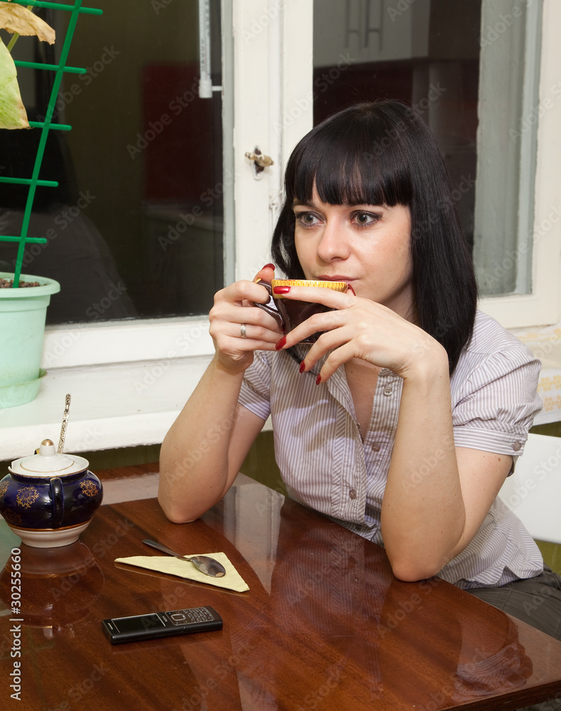Грустная девушка на кухне пьёт кофе. Stock Photo | Adobe Stock