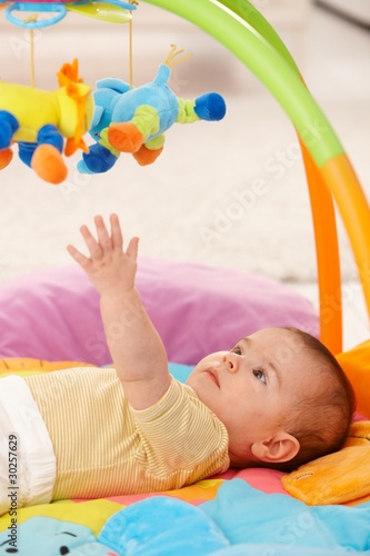 Baby reaching for toy photo