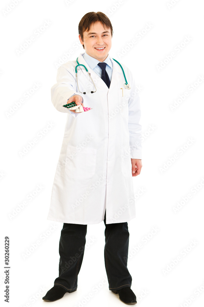 Smiling medical doctor holding packs of pills in hand Smiling medical doctor holding packs of pills in hand