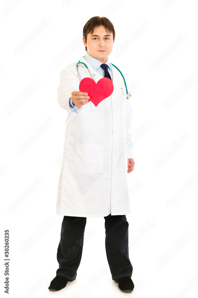Smiling medical doctor holding paper heart in hand Smiling medical doctor holding paper heart in hand