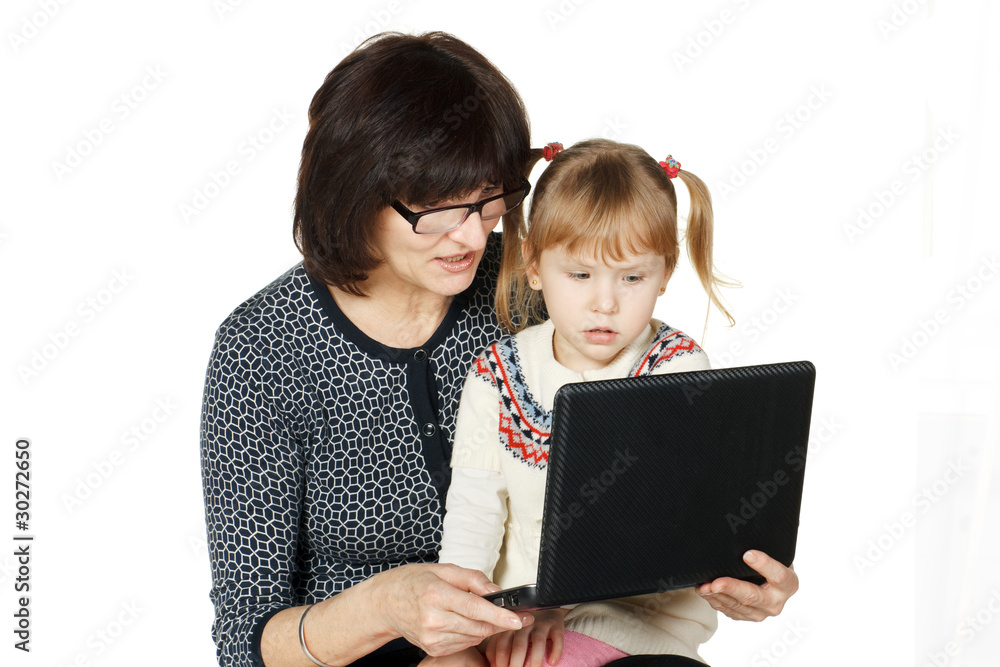 Grandmother demonstrating her granddaughter smth in laptop Grandmother demonstrating her granddaughter smth in laptop