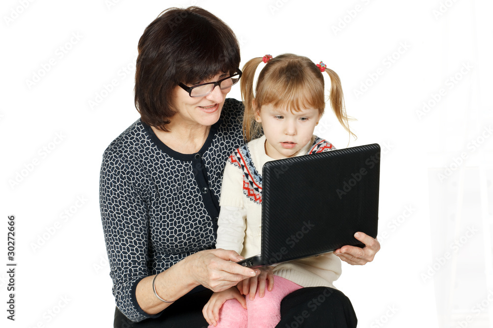 Grandmother demonstrating her granddaughter smth in laptop Grandmother demonstrating her granddaughter smth in laptop