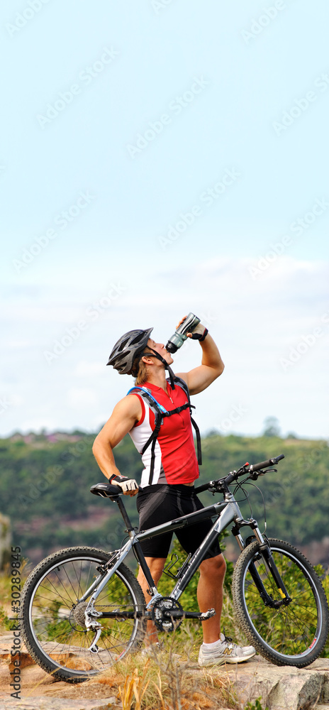 Man drinks on mountain with bicycle