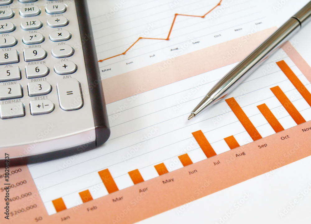 Calculator and pen on the investment chart Calculator and pen on the investment chart