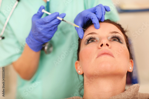 Woman receiving cosmetic injection to forehead