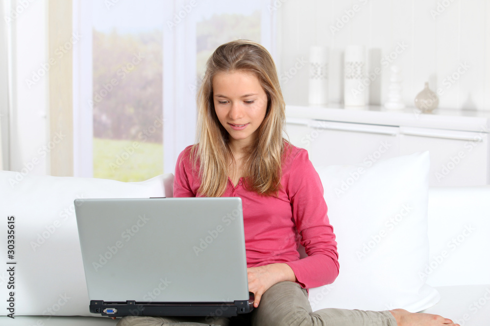 Blond teenager connected on internet at home Blond teenager connected on internet at home