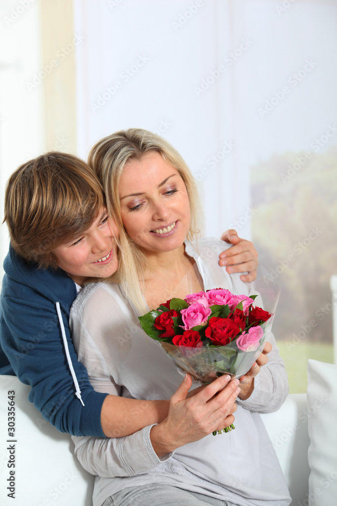 Son offering bunch flowers on mother's birthday Son offering bunch flowers on mother's birthday