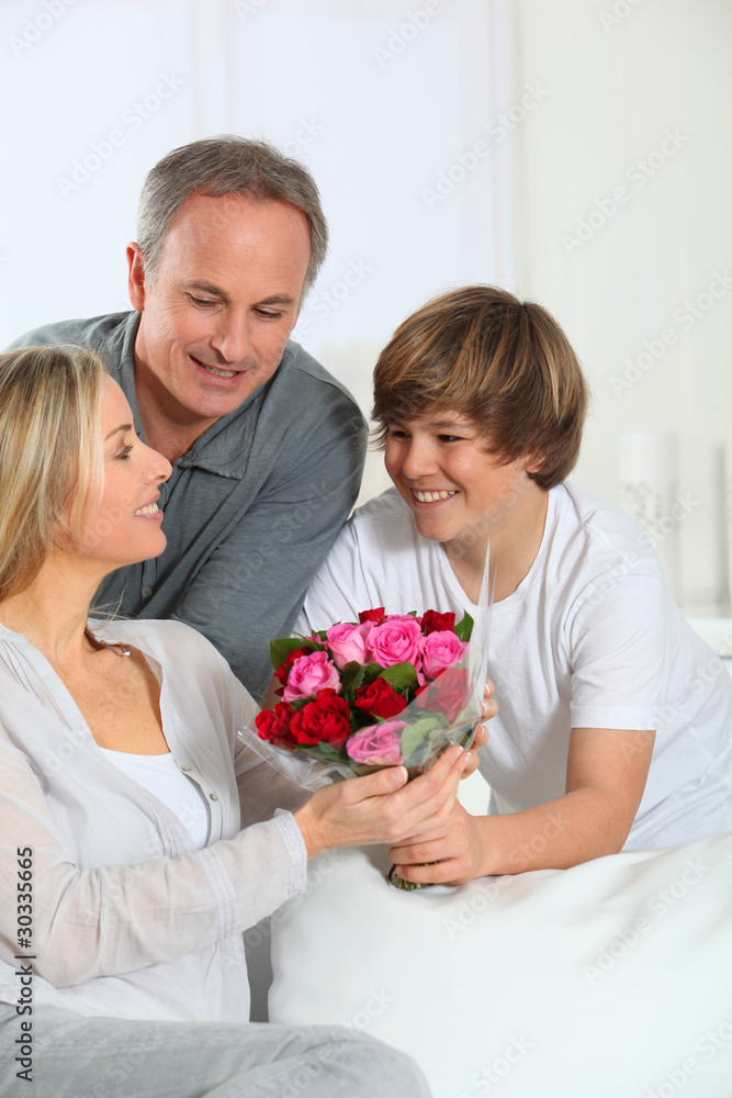 Son offering bunch flowers on mother's day Son offering bunch flowers on mother's day