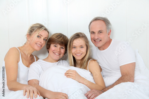 Portrait of happy family in bed in the morning
