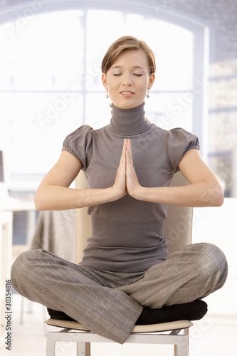 Young businesswoman practicing yoga