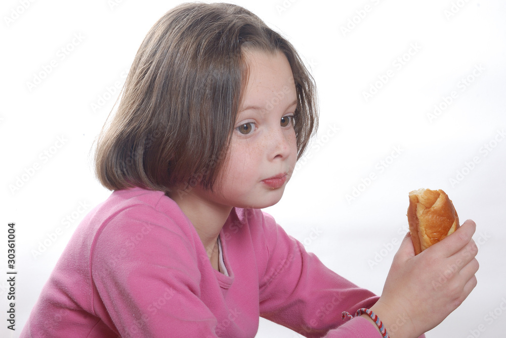 A young girl eating a bun A young girl eating a bun