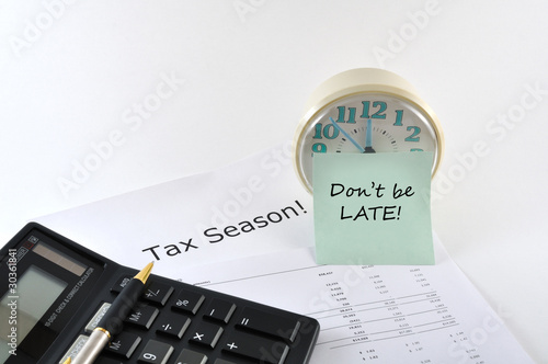 Tax Season. Don`t be late. Concept Image with calculator and clo