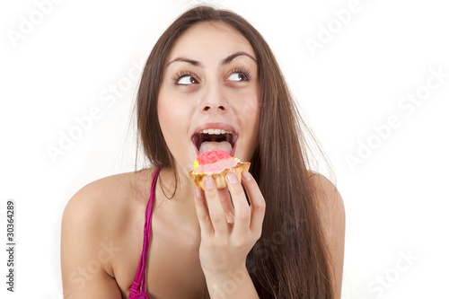 Pretty girl eating cream cake isolated on white