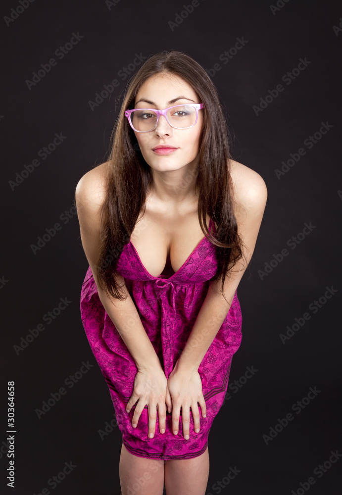 Obraz premium Pretty young girl in red dress posing in studioon dark backgroun