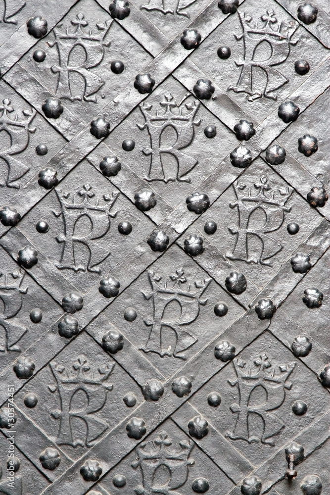 Obraz premium Old door with ornament in stone wall. Royal Wawel Castle.