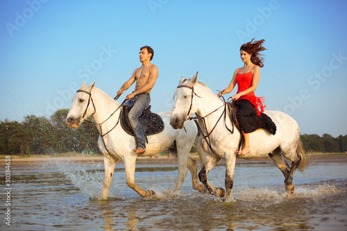 Fototapeta Naklejka Na Ścianę i Meble -  Man and a woman in love with the sea on horseback