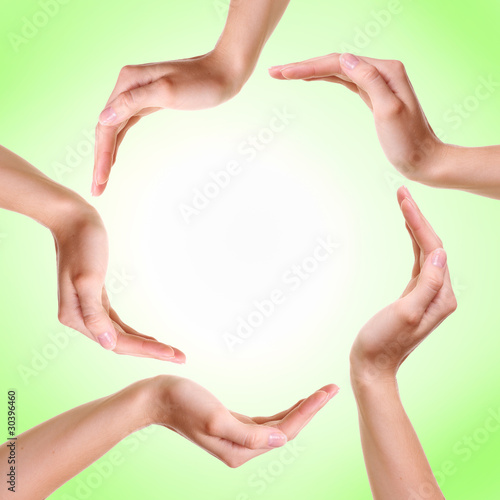 Woman's hands made circle on green background