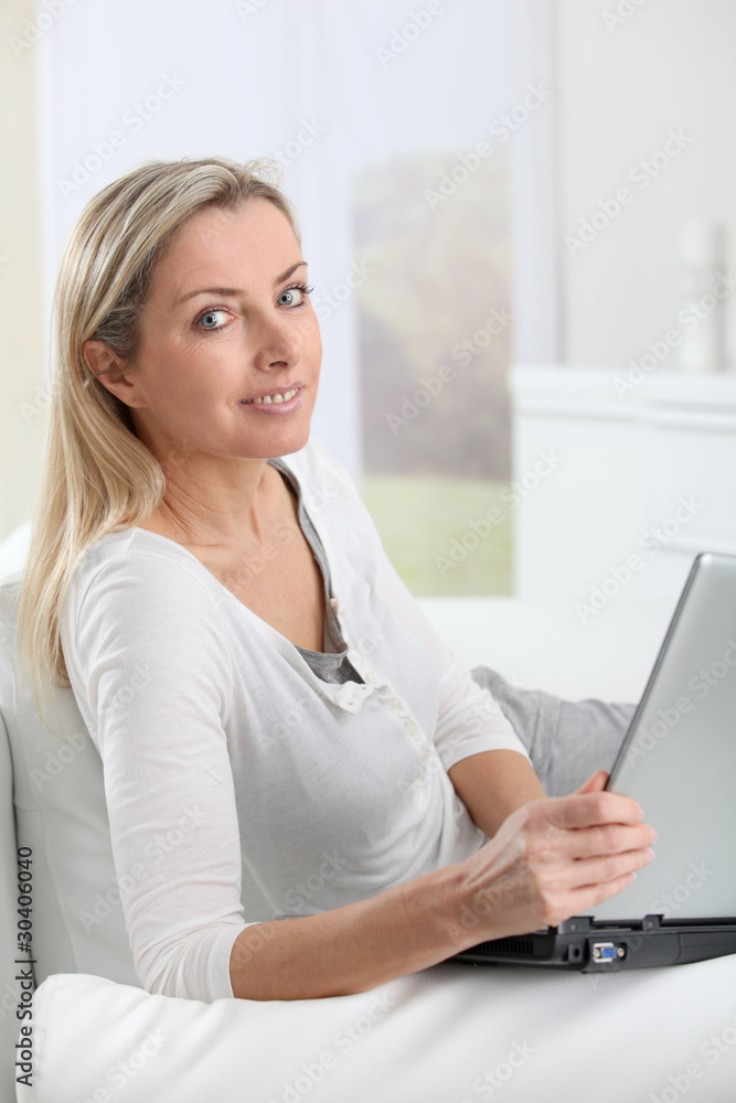 Adult blond woman connected on internet at home Adult blond woman connected on internet at home