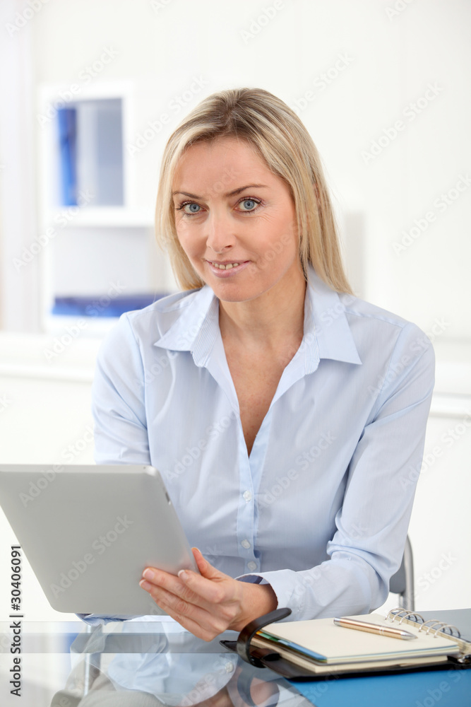 Portrait of office worker using electronic tablet in office