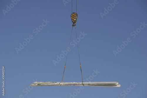 Construction crane lifting metal bars