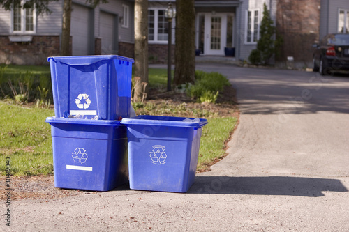 Three small recycle bins on curb