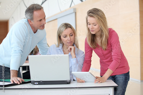 Teachers and teenage girl in front of computer