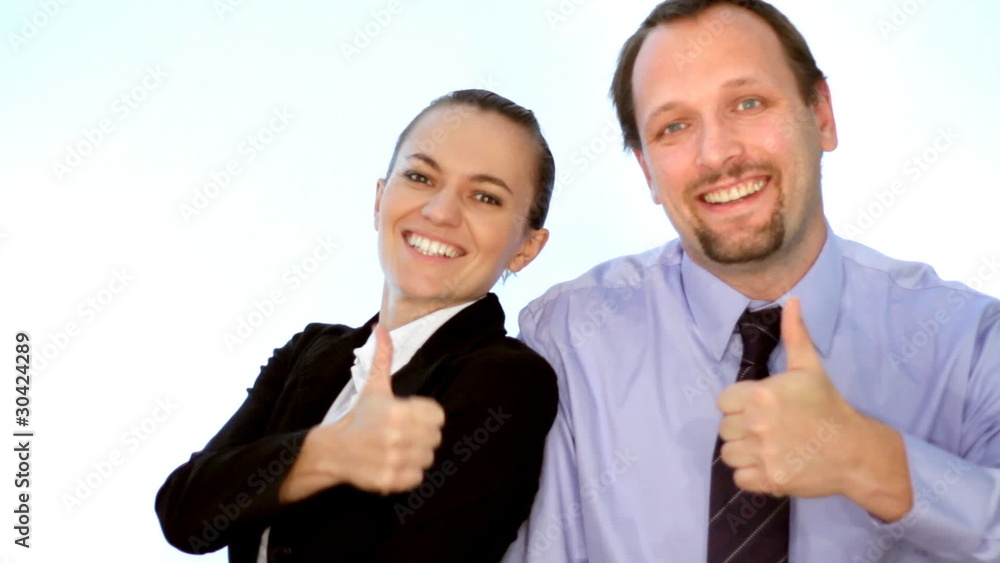 Young smiling business people showing thumbs up sign, isolated Young smiling business people showing thumbs up sign, isolated