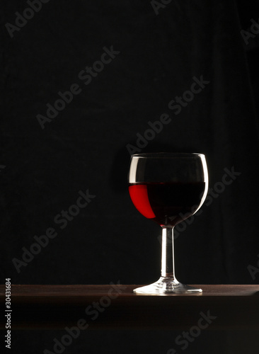 bicchiere di vino rosso su fondo nero
