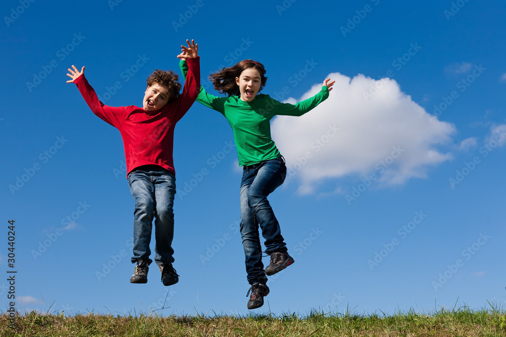 Girl and boy jumping, running against blue sky Girl and boy jumping, running against blue sky